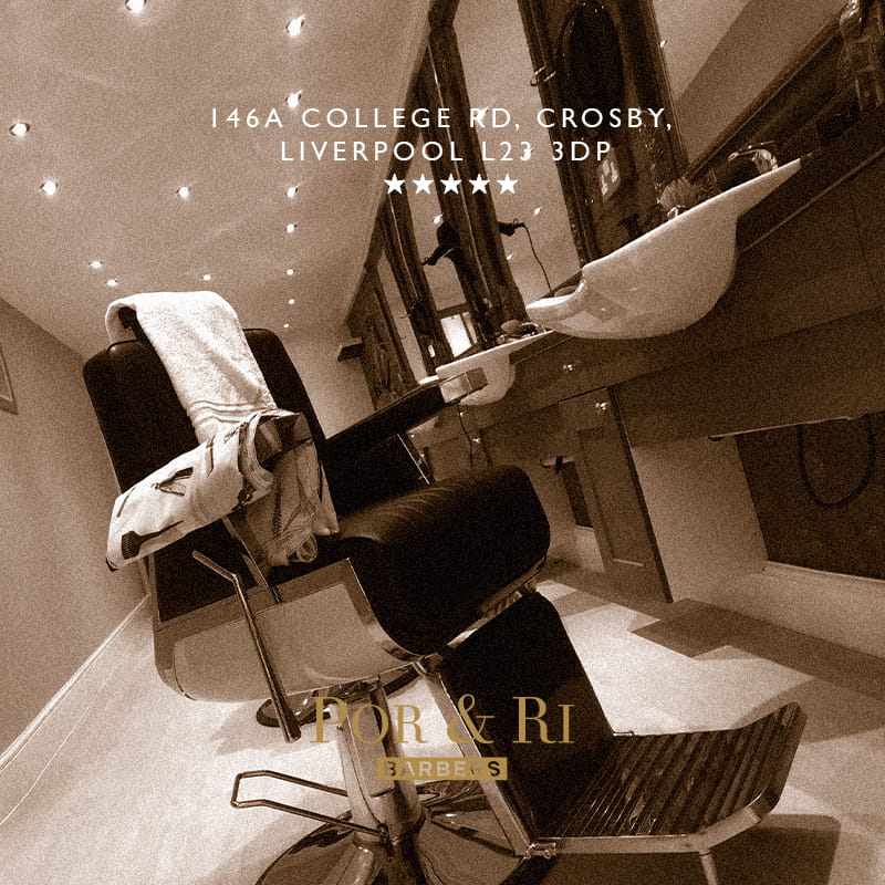 Interior of Por & Ri Barbers showing a modern barber chair, wash basin, and illuminated mirrors in a stylish grooming space.